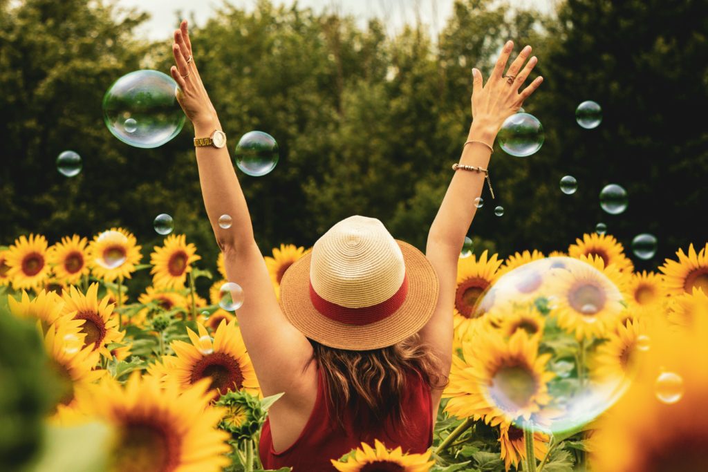 Una chica de espaladas en un campo de girasoles.