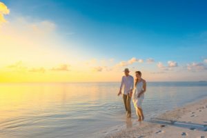 Imagen de una pareja de la mano andando por la playa.