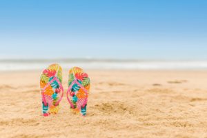 Dos chanclas en una playa para un artículo de Vivir en Astrológico.