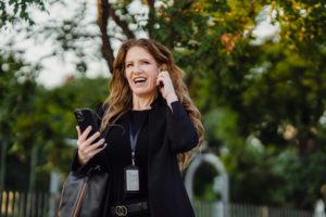 Mujer sonriendo con un móvil para un artículo de Vivir En Astrológico.